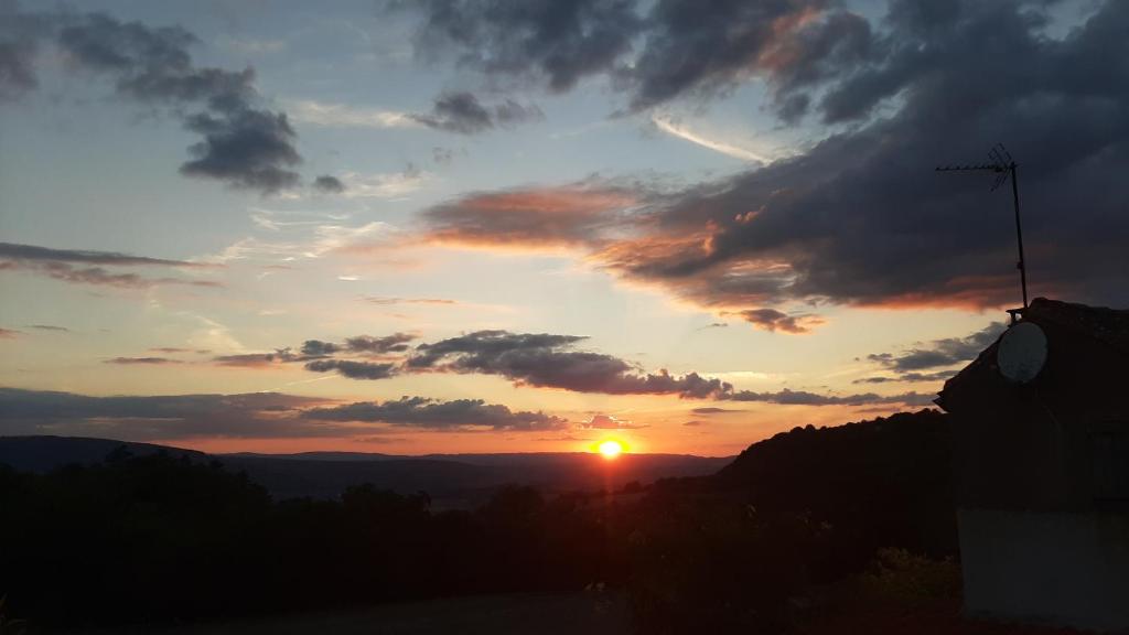 a sunset with the sun setting in the sky at Un balcon entre Causses et Rougiers in Gissac