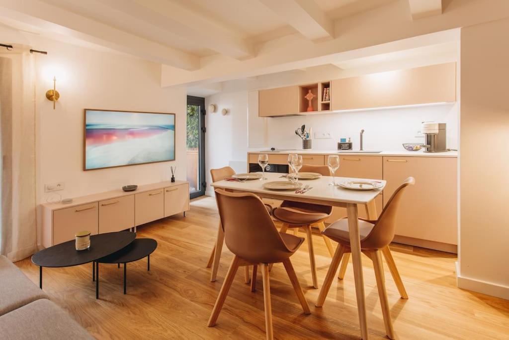 eine Küche und ein Wohnzimmer mit einem Tisch und Stühlen in der Unterkunft La Vie en Rose - Luxe, calme & hypercentre - 3* in Annecy