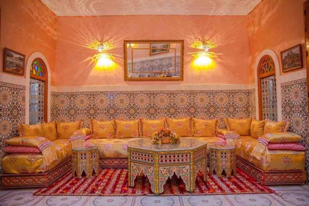 ein Wohnzimmer mit einem Sofa und einem Tisch in der Unterkunft Dar lmrama Guest House Fes Medina Morocco in Fès