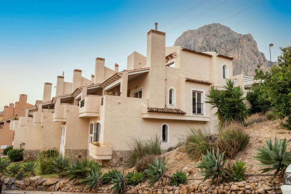 a building in the desert with a mountain in the background at Agradable adosado con maravillosas vistas in Calpe
