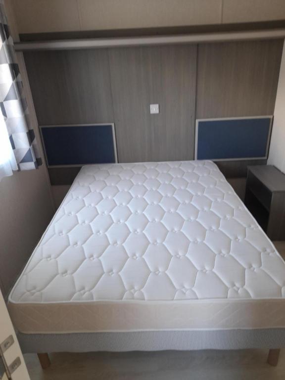 łóżko w pokoju z białym materacem w obiekcie le mobile home Le Victory situé au Camping Le Rio w mieście Noyelles-sur-Mer