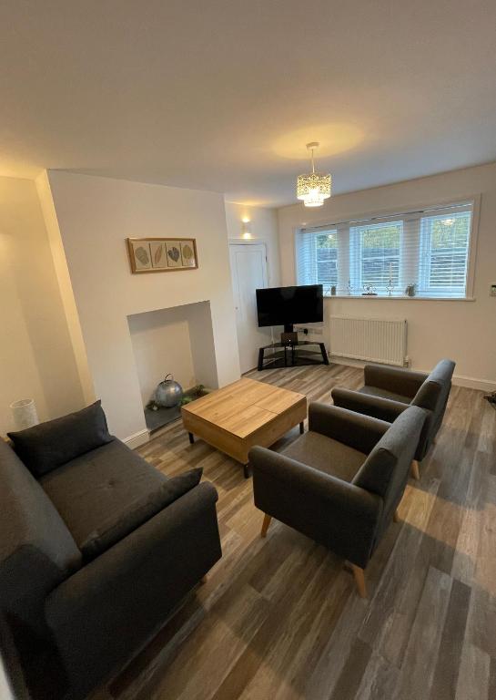 a living room with two couches and a television at Ebor Mill's Cottage in Haworth