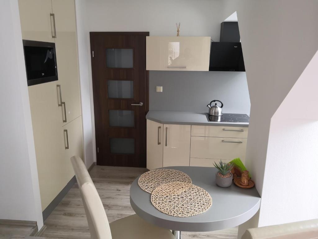 una pequeña cocina con mesa y sillas en una habitación en Apartmánový byt Třemošná Revoluční 144, en Třemošná