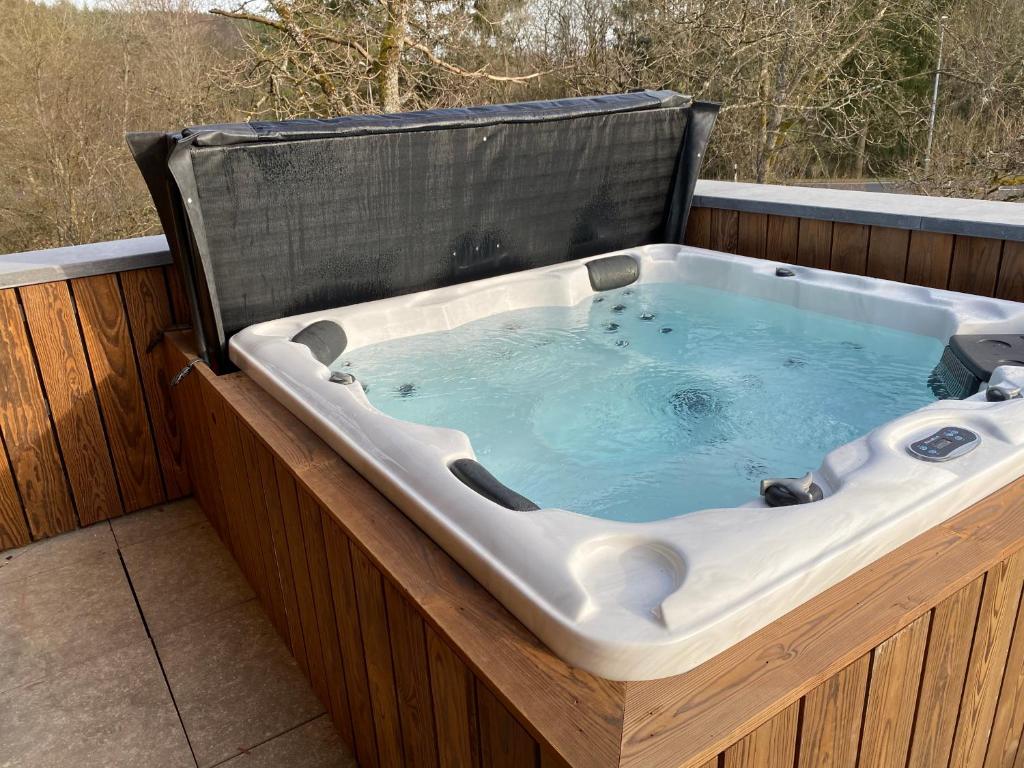 a jacuzzi tub sitting on a deck at Le chalet du kanal in Winseler