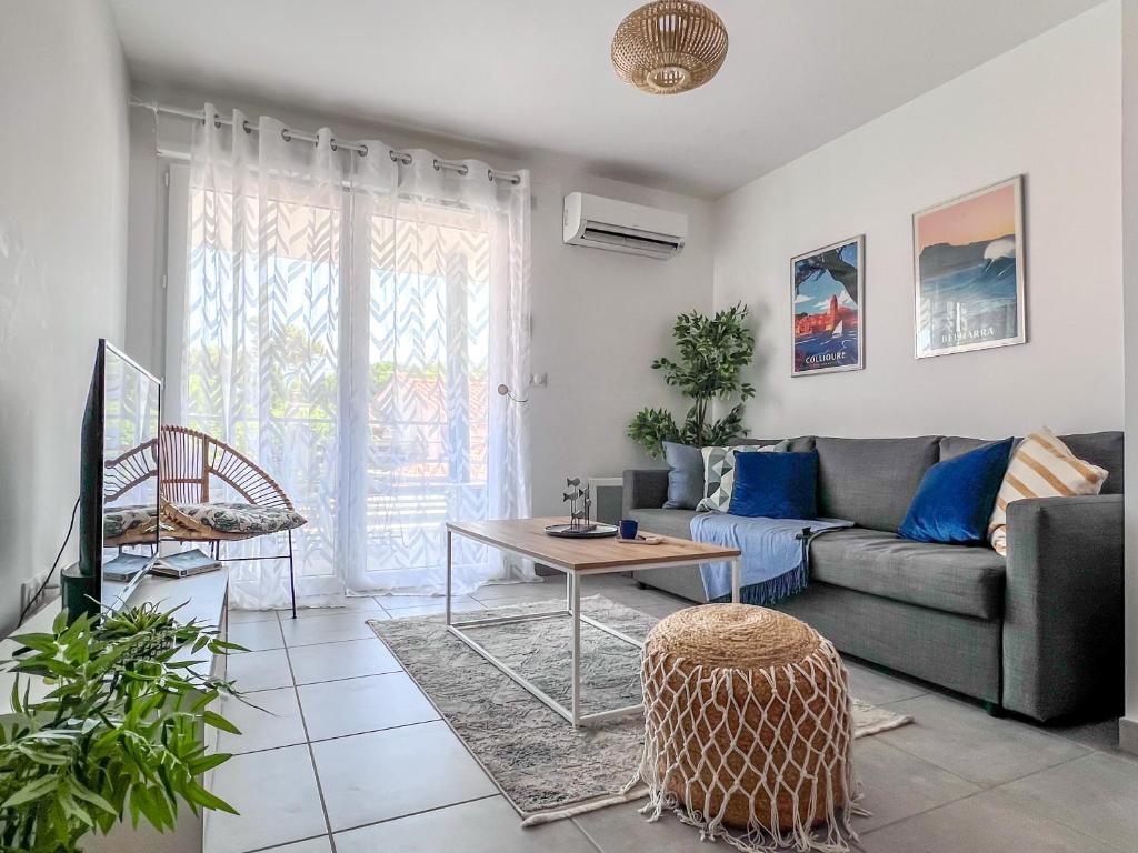 sala de estar con sofá y mesa en Superbe appartement neuf entre mer et pins Wifi en Argelès-sur-Mer