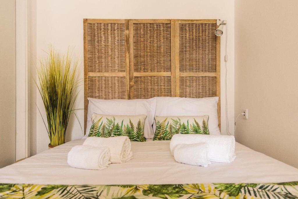 un letto con due cuscini e una finestra di Suites Bambu a Setúbal