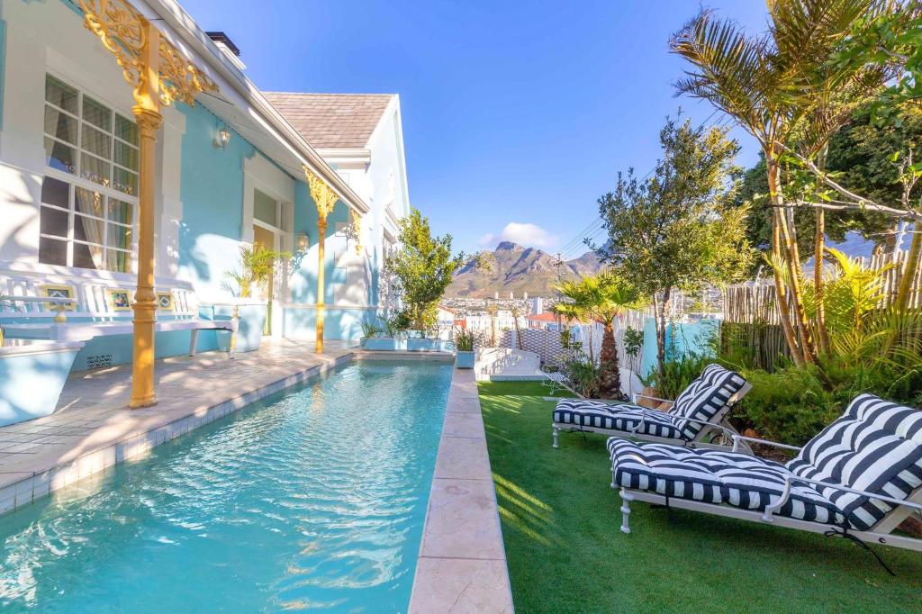 a house with a swimming pool next to a house at Amina Boutique Hotel in Cape Town