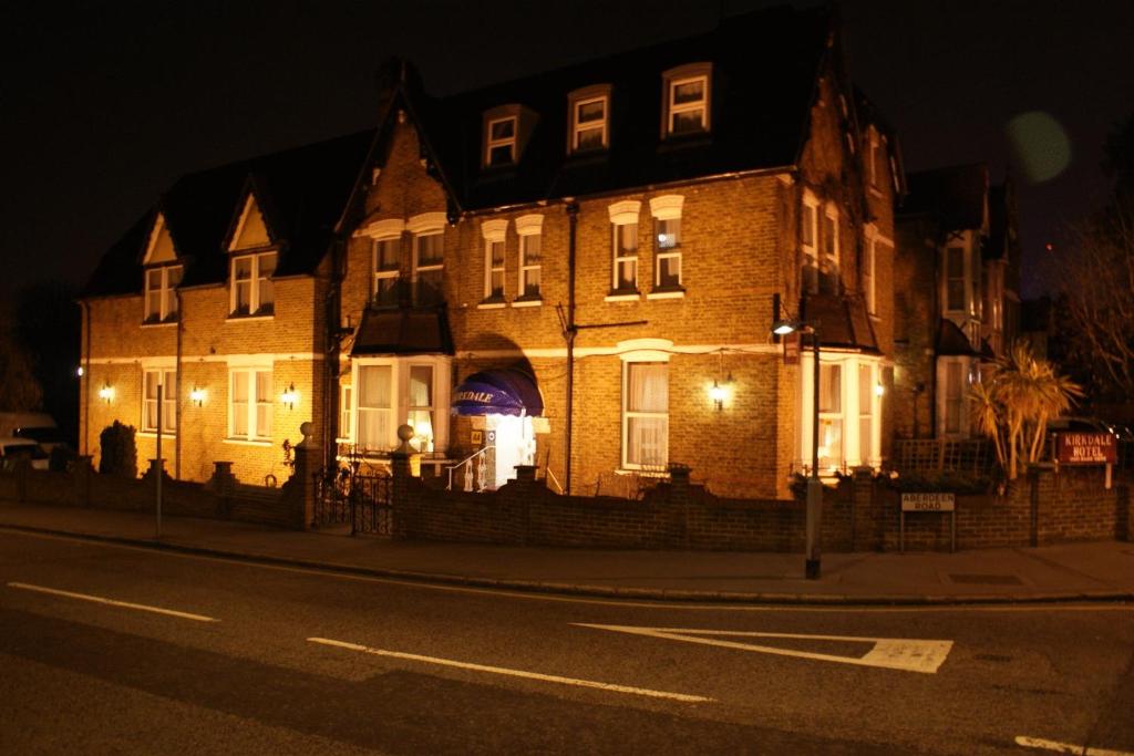 a large brick building on a city street at night at Kirkdale Hotel in Croydon