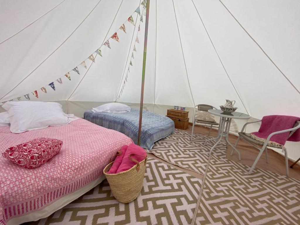 Charlton End Bell Tent في Charlton: غرفة نوم بسرير وخيمة