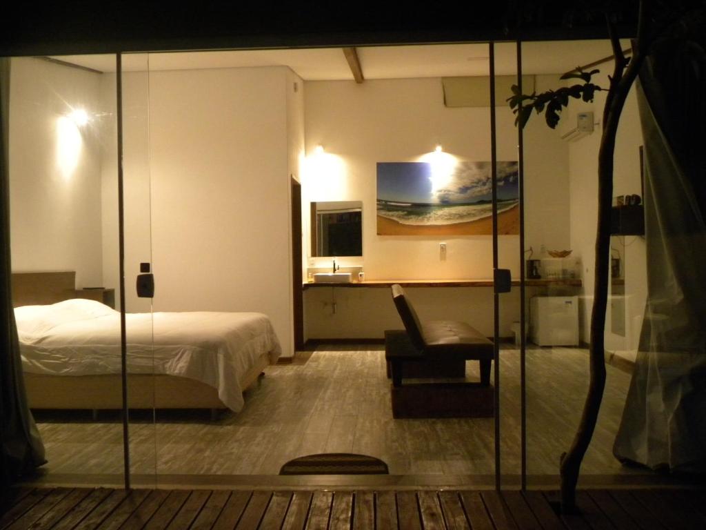 um quarto de hotel com uma cama e uma cadeira em Green Lodge Eco Life Hotel em Florianópolis