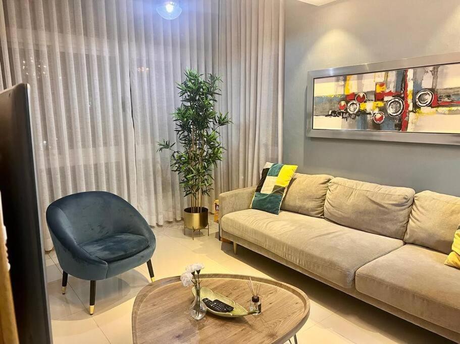 sala de estar con sofá, silla y mesa en 1BR Luxury apartment Pool, gym, rooftop Santo Domingo, en Santo Domingo