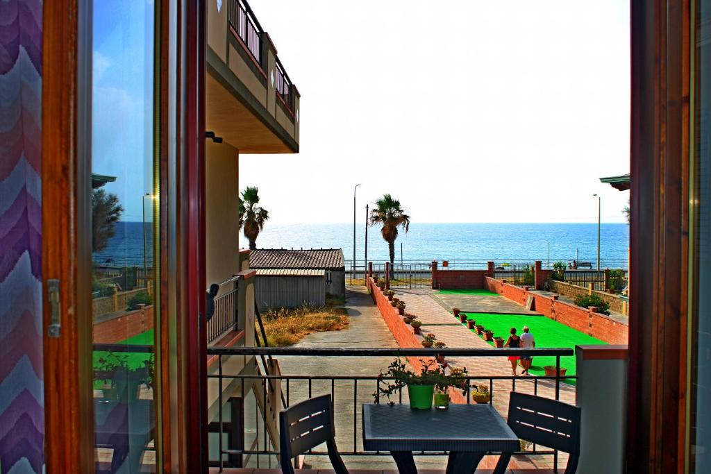 a balcony with a table and a view of the ocean at Capo d'Orlando Apartments - Cipria in Capo dʼOrlando
