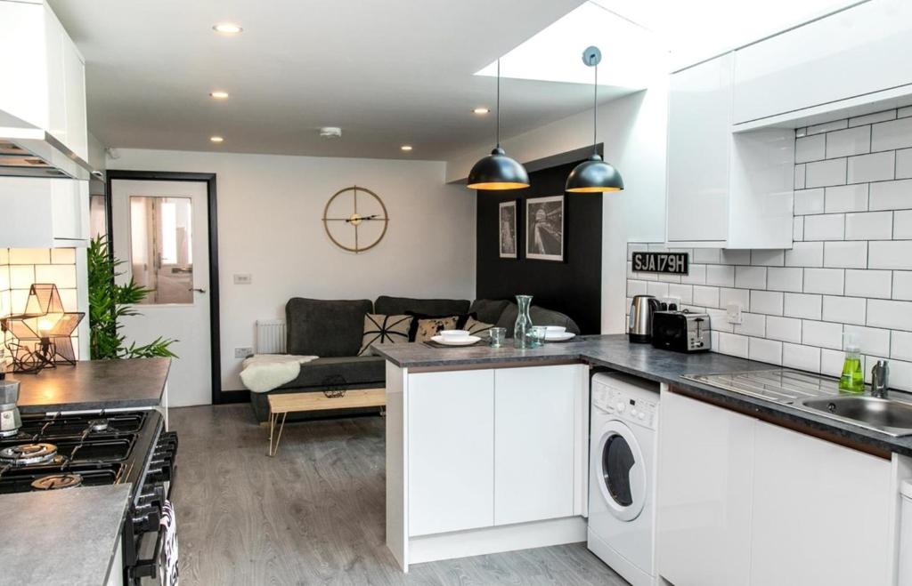 a kitchen and living room with white cabinets and a couch at Room in a Shared House, Dean Street, CV2 in London