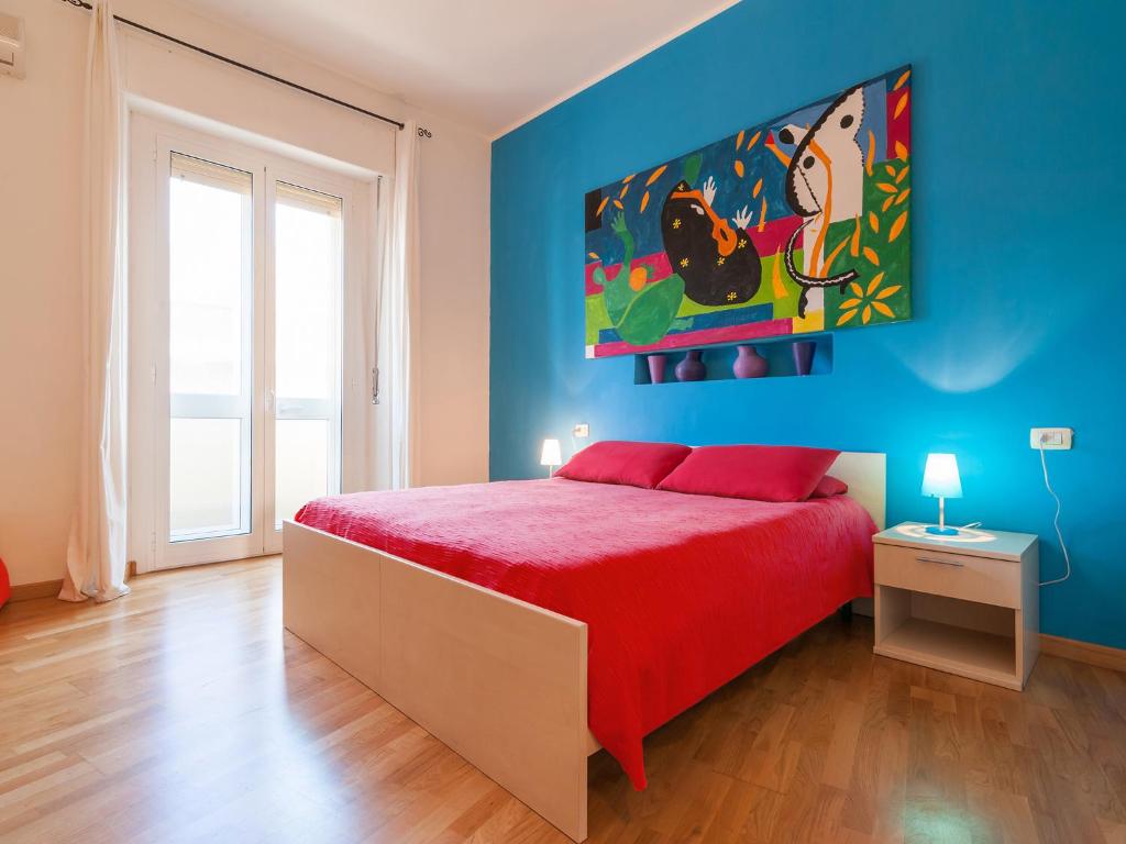 カリアリにあるAffittacamere Art Roomsの赤いベッドと青い壁のベッドルーム1室