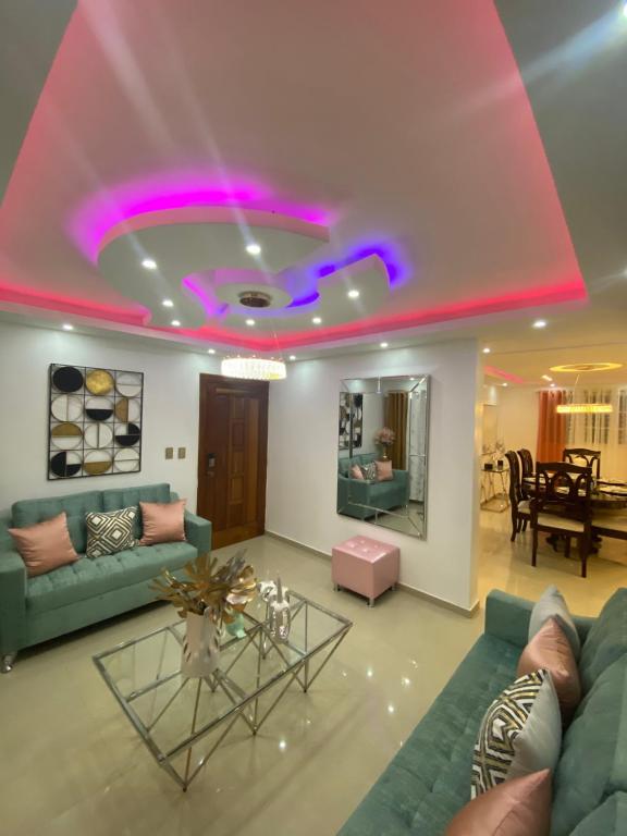 un soggiorno con luci viola sul soffitto di VIP Home a Santiago de los Caballeros