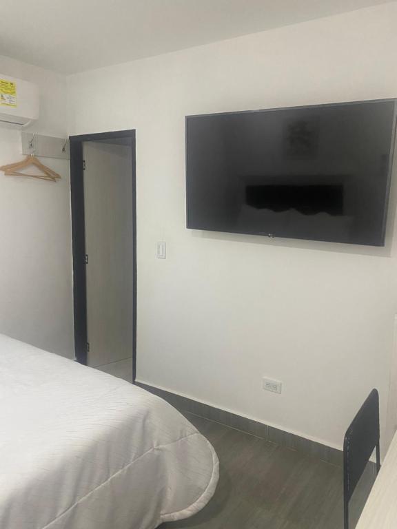 a bedroom with a flat screen tv on a wall at Hotel Casa Luna in Cúcuta