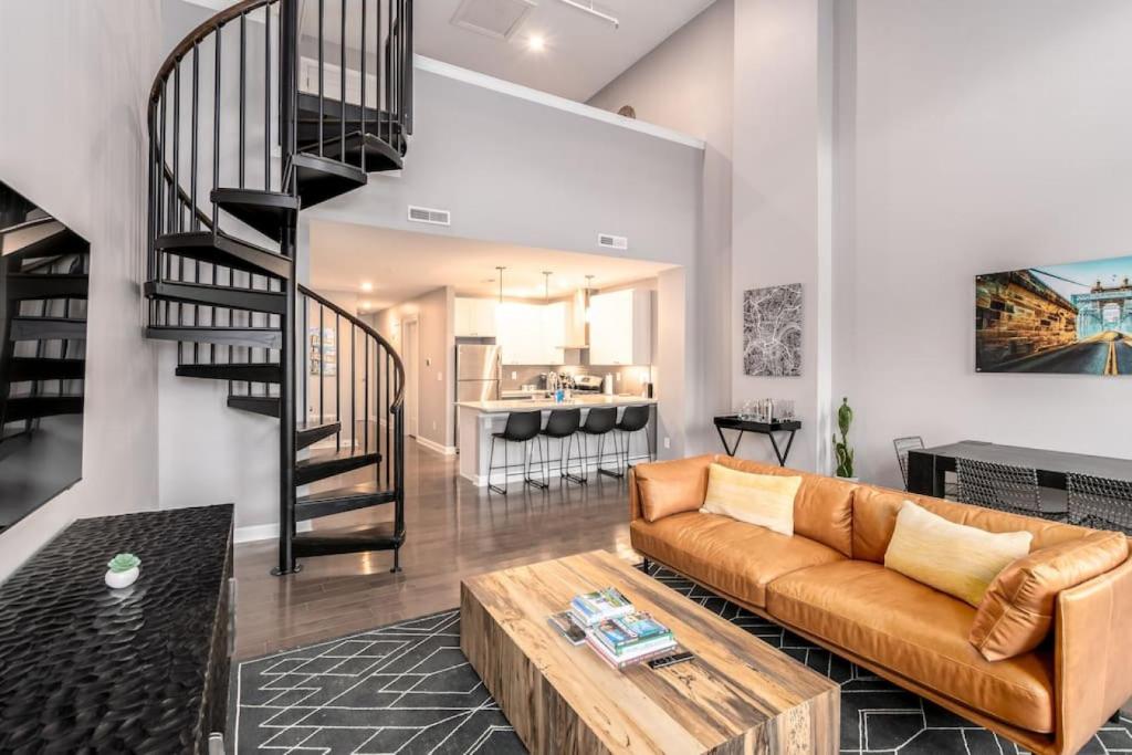 sala de estar con sofá y escalera en Soaring 2-Bedroom Parkside Loft Walkable to it All, en Cincinnati