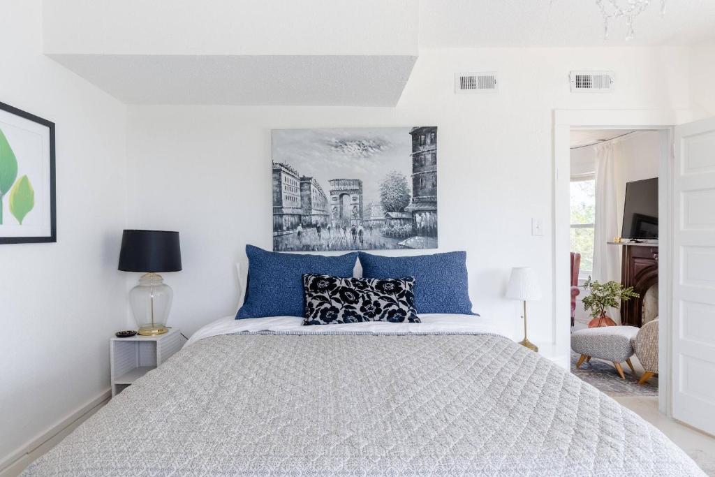 a white bedroom with a large bed with blue pillows at Boutique Apartment in 1905 Victorian Home - Plaza - Westport in Kansas City