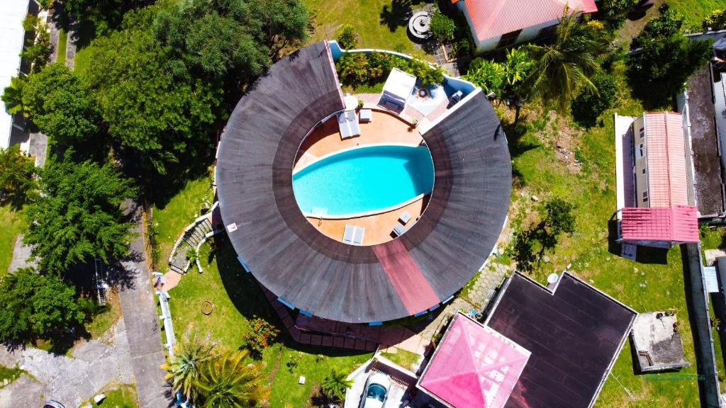 an overhead view of a swimming pool with a large circular building at Villa le Moulin - Didier BERVILLE in Le Gosier