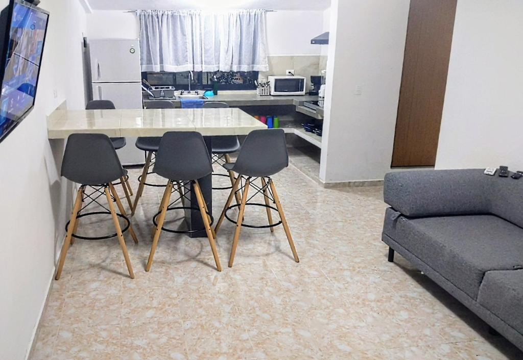cocina con mesa, 4 sillas y sofá en El Departament del Port, en Cancún