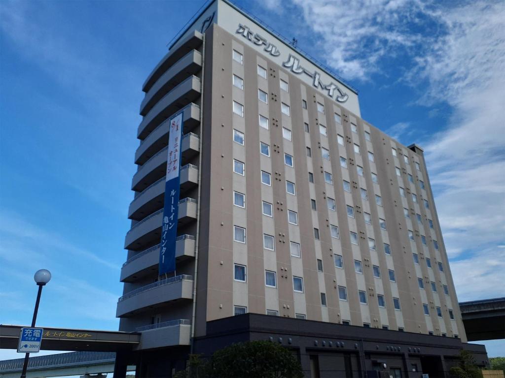 un bâtiment avec un panneau sur son côté dans l'établissement Hotel Route-Inn Kameyama Inter, à Kameyama