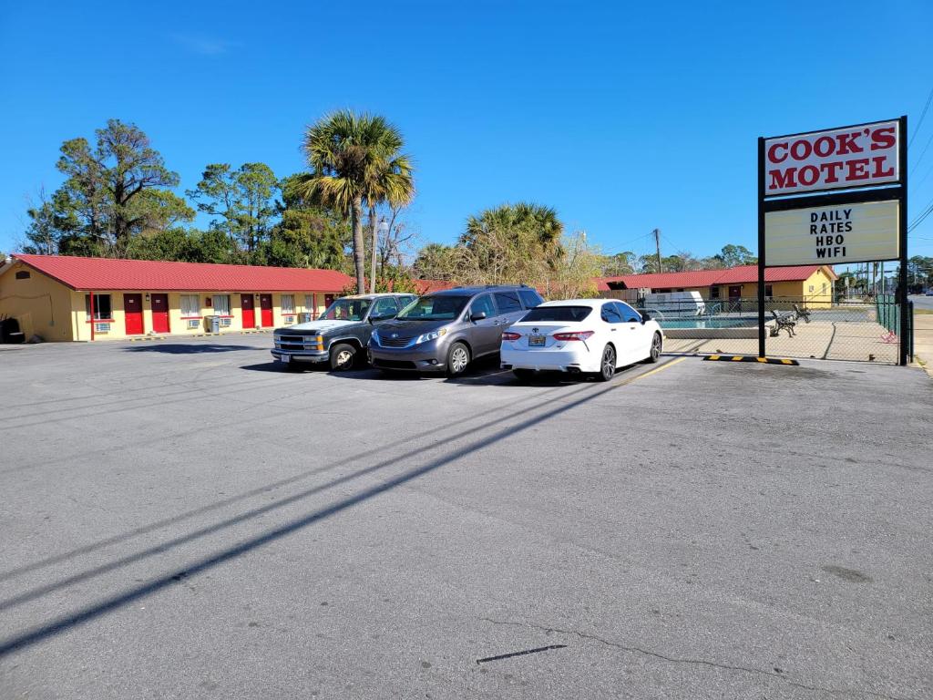 un estacionamiento con autos estacionados frente a un motel en Cook's Motel, en Panama City Beach