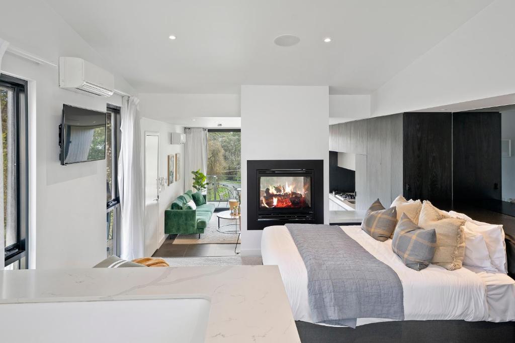 a bedroom with a large bed and a fireplace at Hepburn Bathhouse & Spa Villas in Hepburn Springs