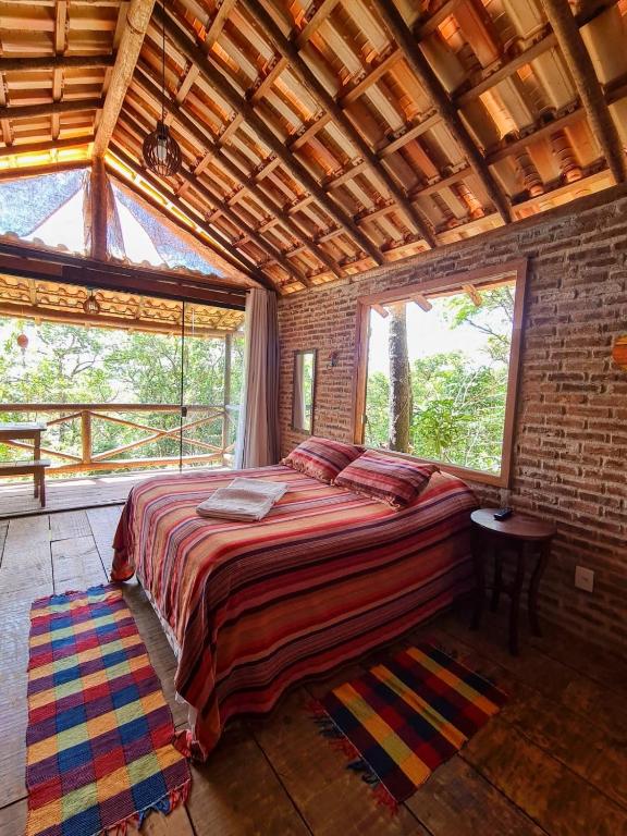 a bedroom with a large bed in a brick wall at Chalé Rústico 3 - Retiro Andaluz in Brumadinho