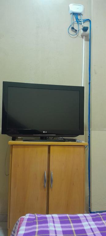 a flat screen tv sitting on top of a wooden cabinet at Hospedaje San Miguel in Luque