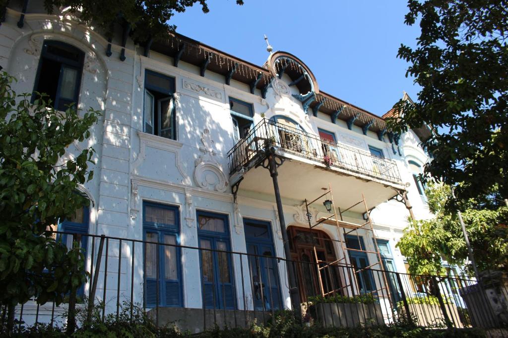 - un bâtiment blanc avec des portes bleues et un balcon dans l'établissement Hostel Cadê Teresa, à Rio de Janeiro