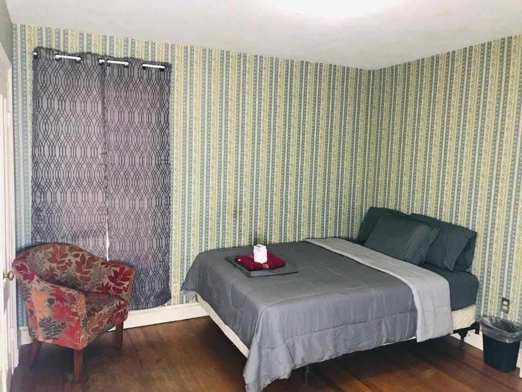 a bedroom with a bed and a chair at Private Room/Min. from Downtown 2 in Hartford