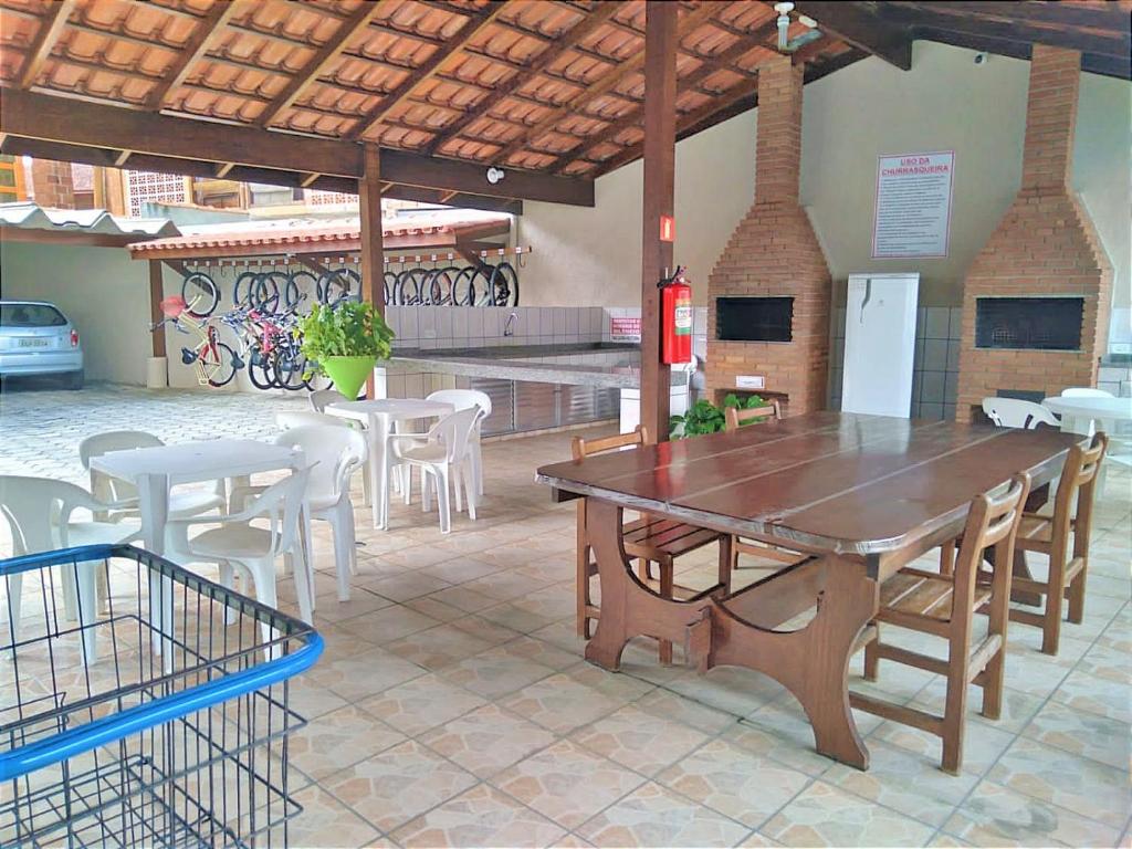 a large wooden table and chairs in a patio at Apartamento Espaçoso Perto da Praia in Caraguatatuba