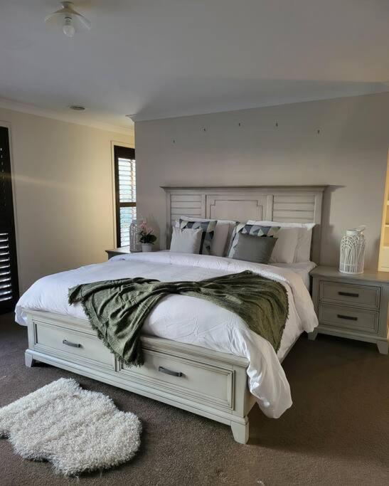 - une chambre avec un grand lit blanc et des oreillers dans l'établissement Luxury Green, à Greenvale