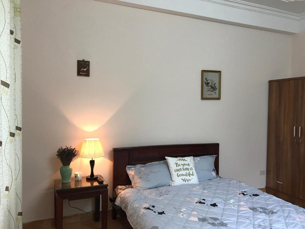 a bedroom with a bed and a lamp on a table at 105 Láng Hạ in Hanoi