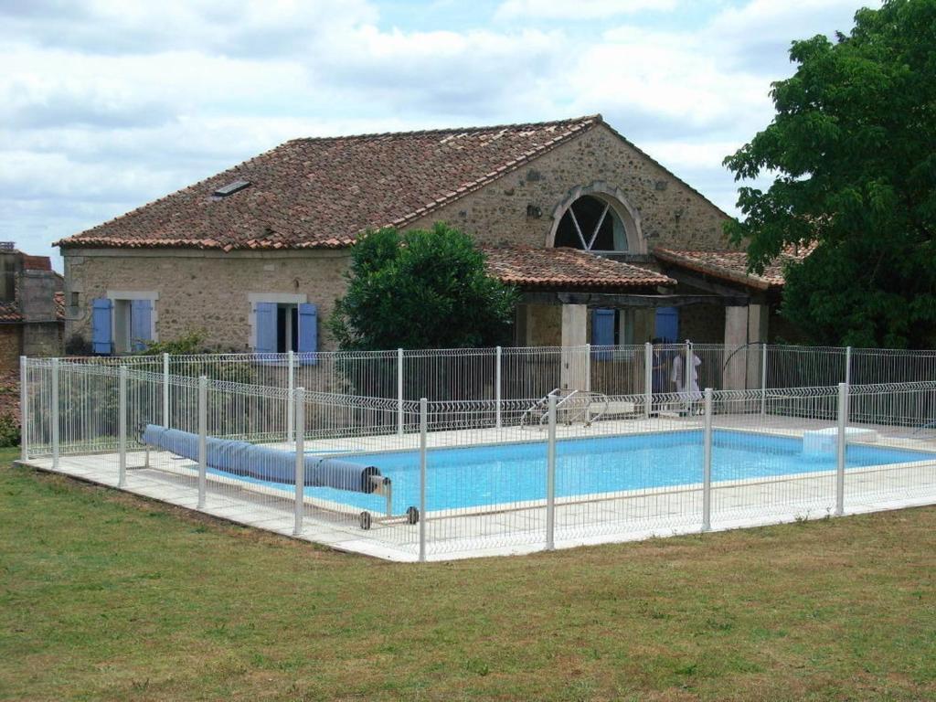 einen Zaun um einen Pool vor einem Haus in der Unterkunft Gîte Charras, 5 pièces, 6 personnes - FR-1-653-7 in Charras