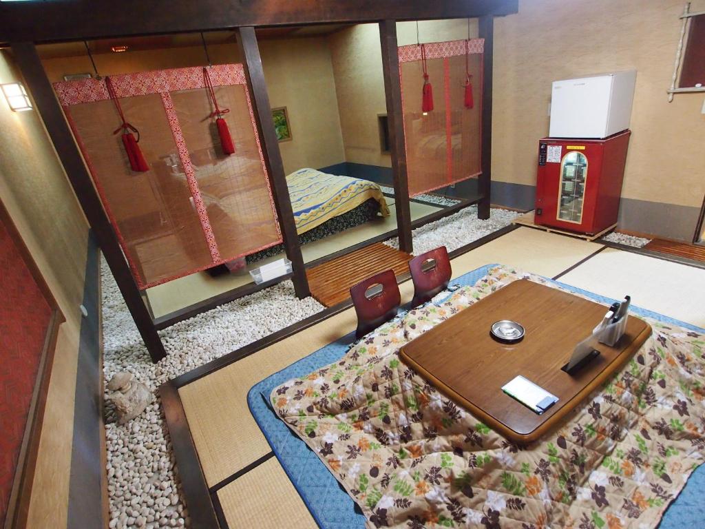 a room with a table and chairs and a bed at ホテルセーラ赤堀店 