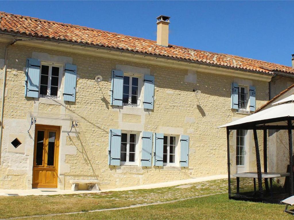 un gran edificio de ladrillo con ventanas azules y una puerta en Gîte Chalais, 5 pièces, 8 personnes - FR-1-653-170, en Chalais