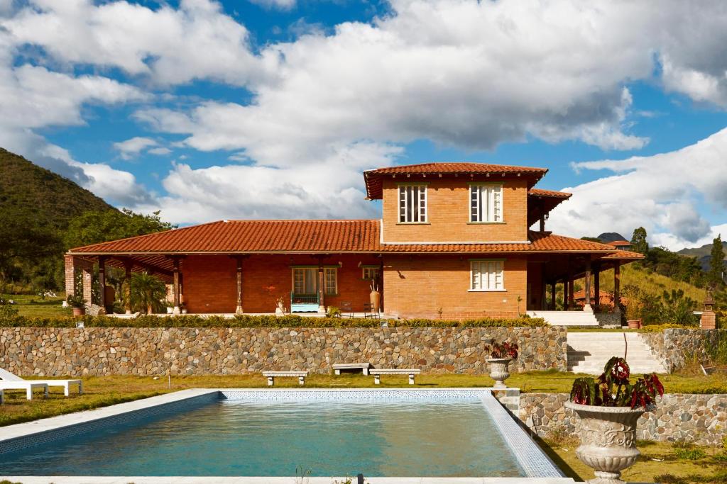 une maison avec une piscine en face d'une maison dans l'établissement VillaBeatriz Lodge&Spa, à Vilcabamba