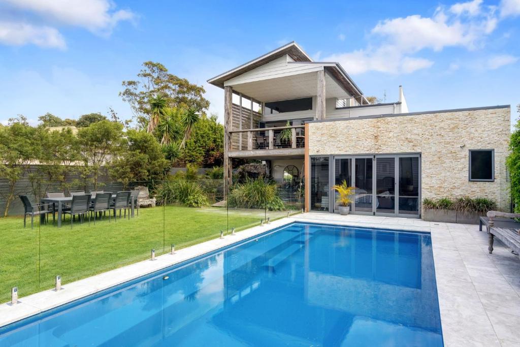 a home with a swimming pool and a house at Araluen House Werri Beach Gerringong in Gerringong