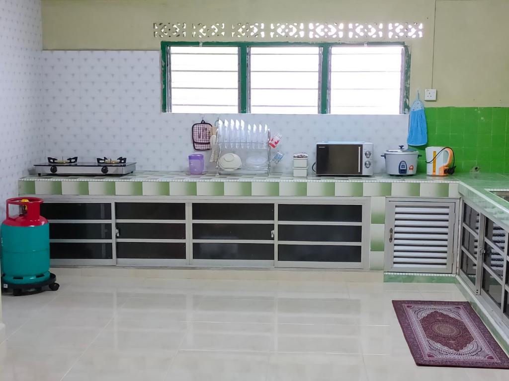 a green and white kitchen with a counter top at Hidden Homestay in Marang