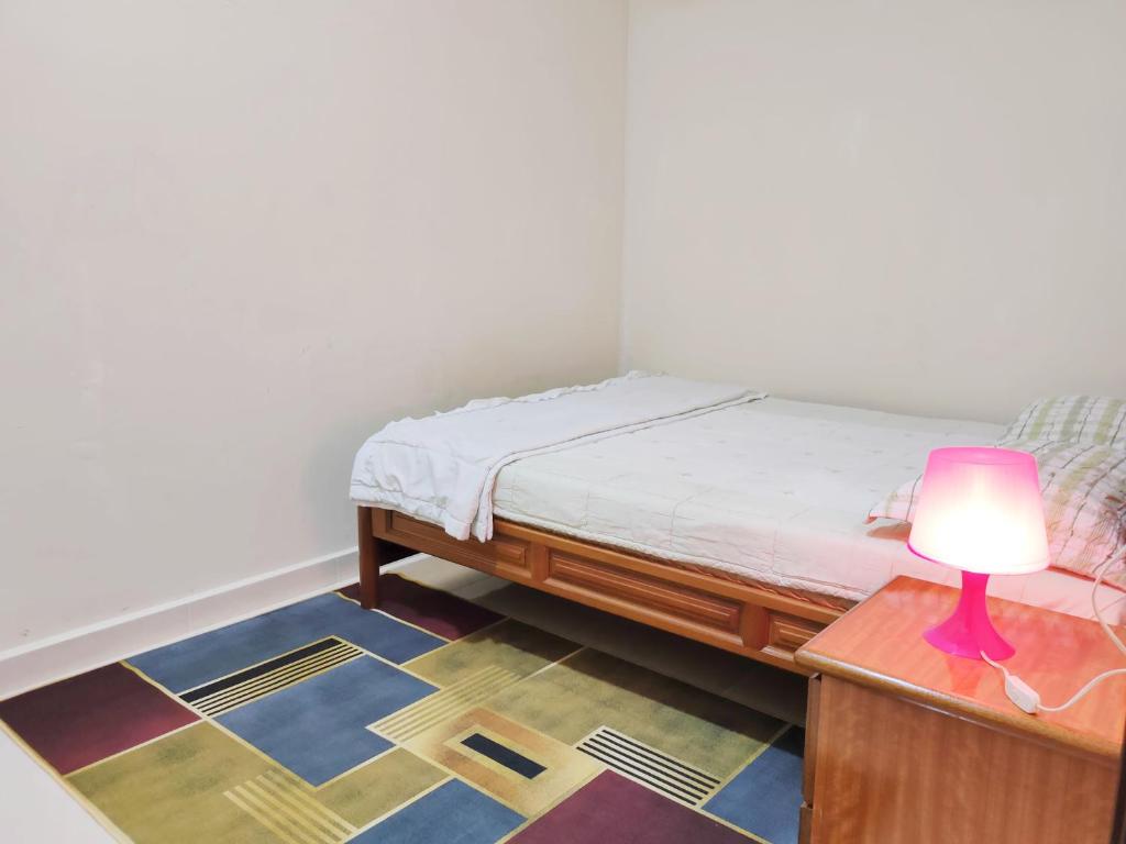 a bedroom with a bed and a lamp on a table at Hidden Homestay in Marang