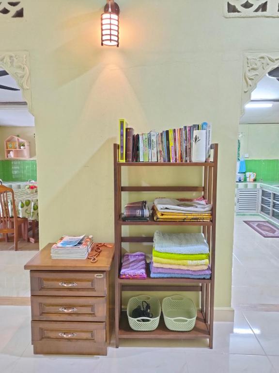 a book shelf with a desk and a drawer at Hidden Homestay in Marang