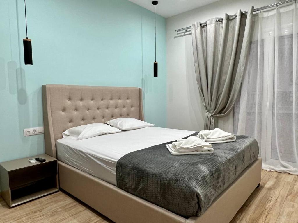 um quarto com uma cama com lençóis brancos e uma janela em ALEX Suite with 2 bedrooms vipgreece em Atenas