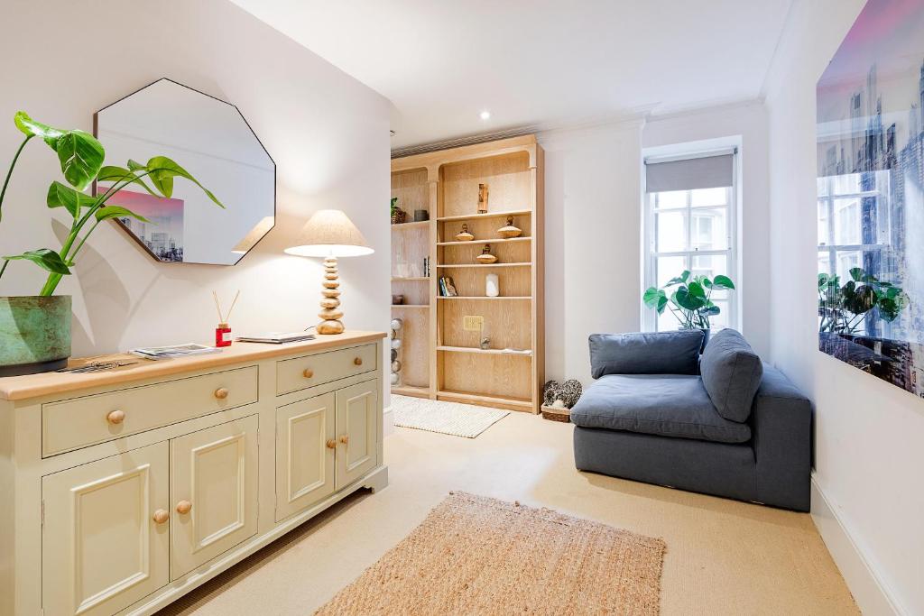 a living room with a blue couch and a mirror at ARCORE Premium Apartments Broad Court in London