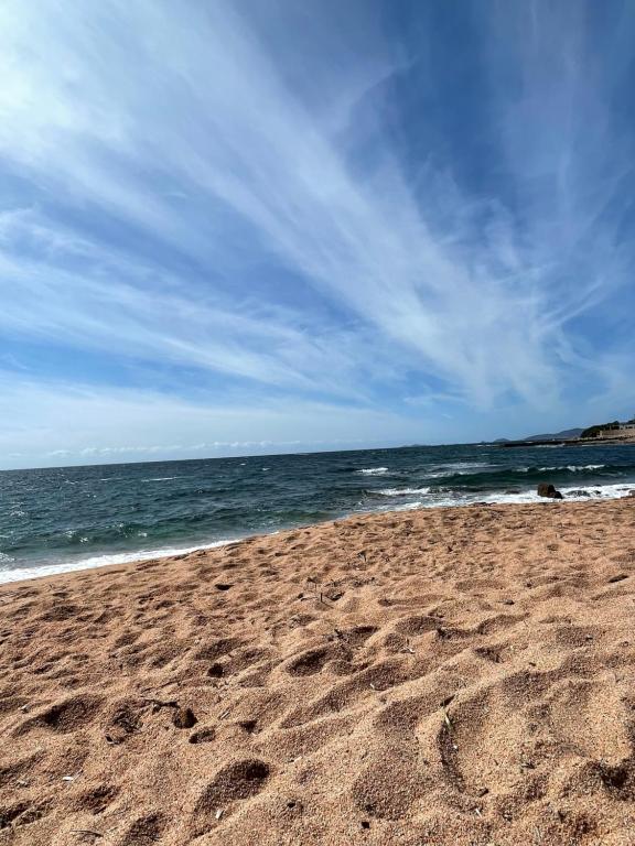 uma praia com pegadas na areia e no oceano em Villa de la Plage em Grosseto-Prugna
