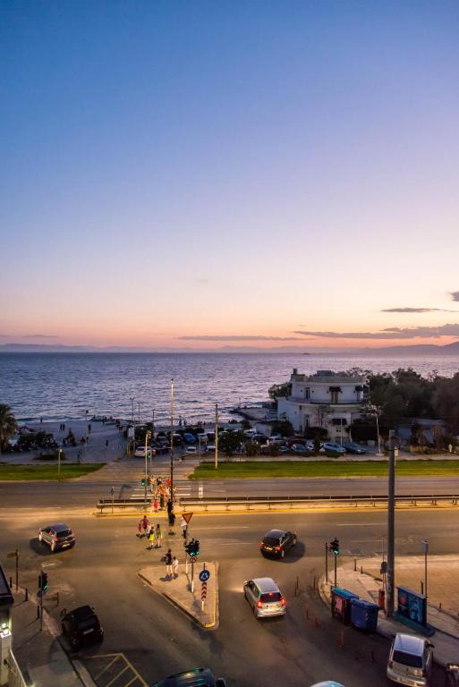 a parking lot with cars parked in front of the ocean at Flisvos Elite Seafront Luxury Apartment in Athens