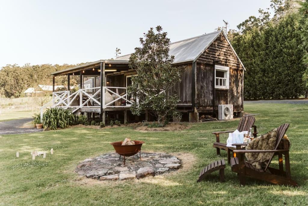 una casa con una hoguera delante de ella en Picturesque Barn located on the Shoalhaven River, en Nowra