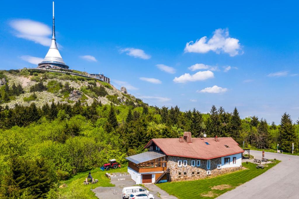 una casa al lado de una colina con una torre en Horská Chata Ještědka, en Světlá pod Ještědem