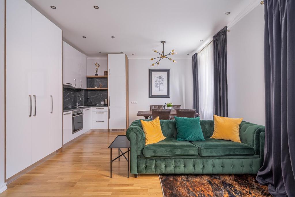 uma sala de estar com um sofá verde e uma mesa em Forest view front line apartment on Dzintaru avenue em Jūrmala