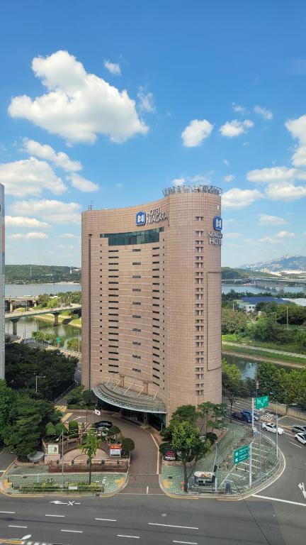 un grand bâtiment d'hôtel en face d'un parking dans l'établissement Niagara Hotel, à Séoul